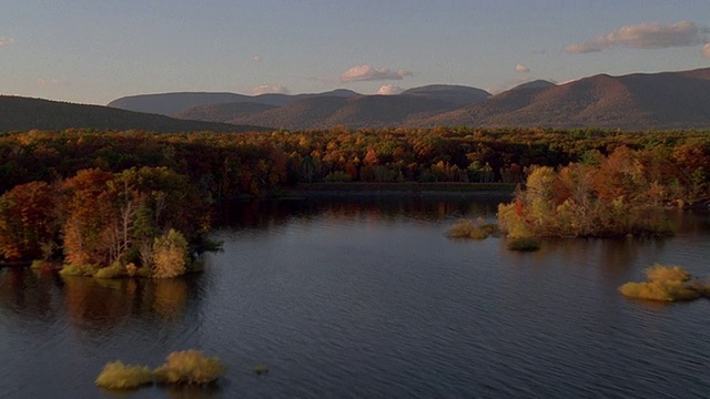 从空中俯瞰湖泊和森林，背景是秋天/新英格兰的山脉视频素材