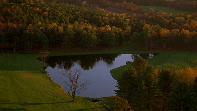 鸟瞰池塘和树木在秋天日落与山的背景/新英格兰视频素材