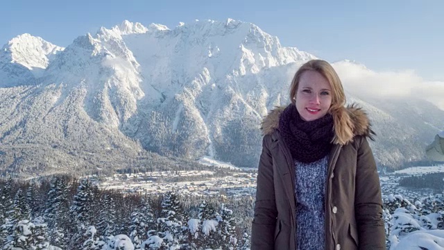 年轻女子的肖像在山前全景在冬天视频素材