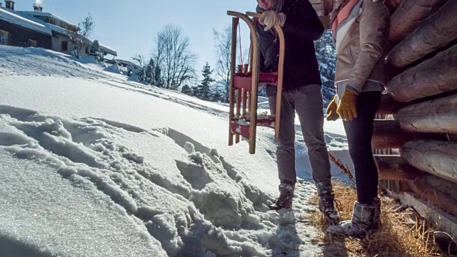 冬天的小木屋里，一对年轻夫妇拉着雪橇视频素材