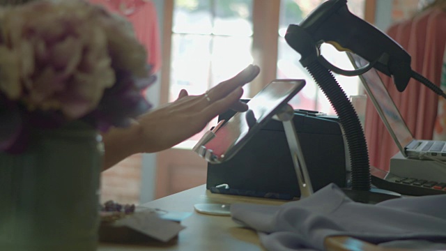 一名年轻女子在市中心一家商店结账时用手指在平板电脑上写下自己的签名。视频素材