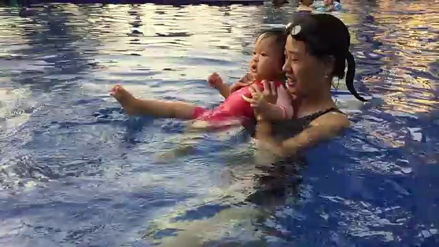 宝宝和妈妈在游泳池里游泳视频素材