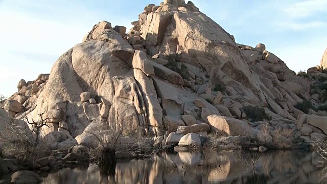 平静的水面反映了约书亚树国家公园的岩层视频下载