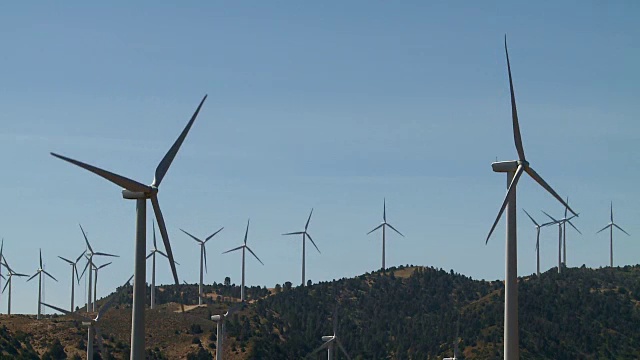 一排风力涡轮机在风电场中旋转视频素材