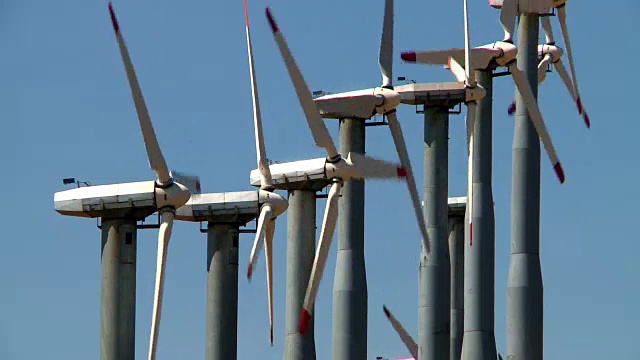 一排风力涡轮机在风电场中旋转视频素材