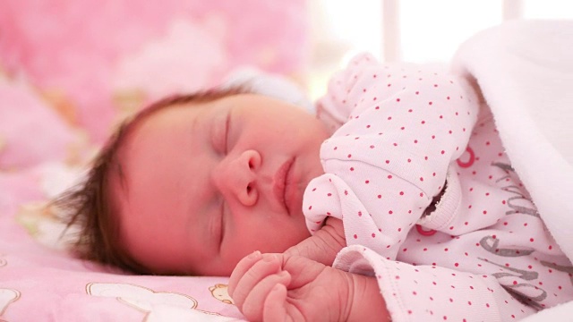 刚出生的女婴睡在家里的婴儿床里视频下载