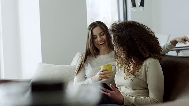 两个女人在沙发上一起喝咖啡视频素材