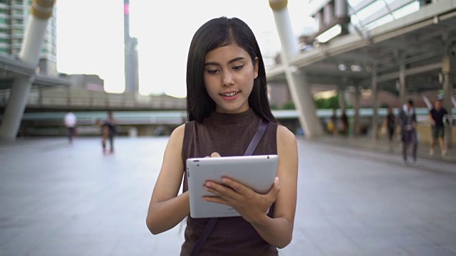 在曼谷市中心用平板电脑的女人非常开心。生活方式的概念。视频素材