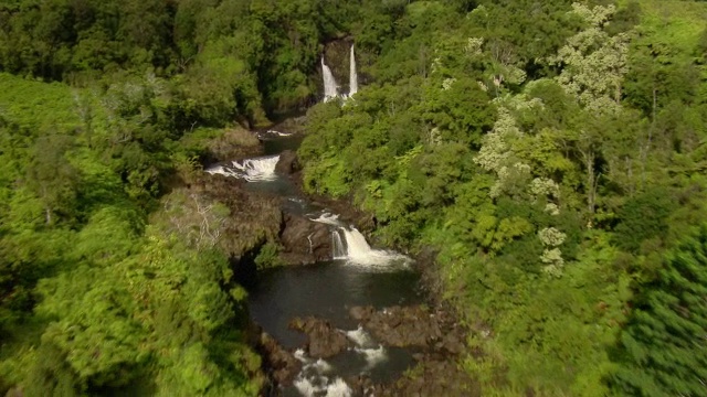 航拍显示几个瀑布依偎在夏威夷郁郁葱葱的风景希洛附近的大岛。视频素材