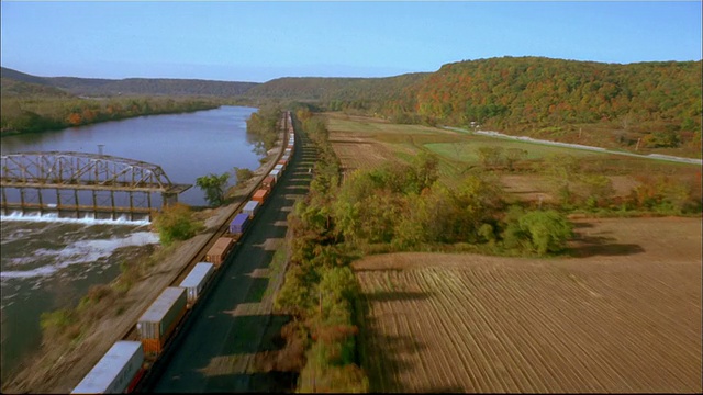 从空中俯瞰货运列车、河流和农田/纽约视频素材