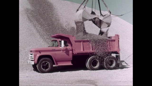 WS PAN在施工现场移动的皮卡，起重机在自卸车中装载沙子/美国视频素材