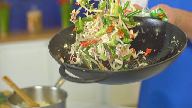 厨师在锅里翻炒蔬菜，慢动作视频素材