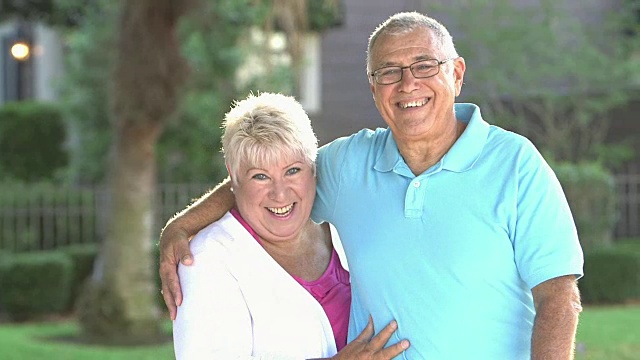 一对快乐的老年夫妇在院子里对着镜头微笑视频素材