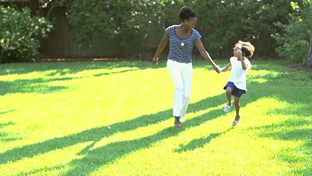 黑人妈妈跑着，跳绳，和小女孩玩着视频素材