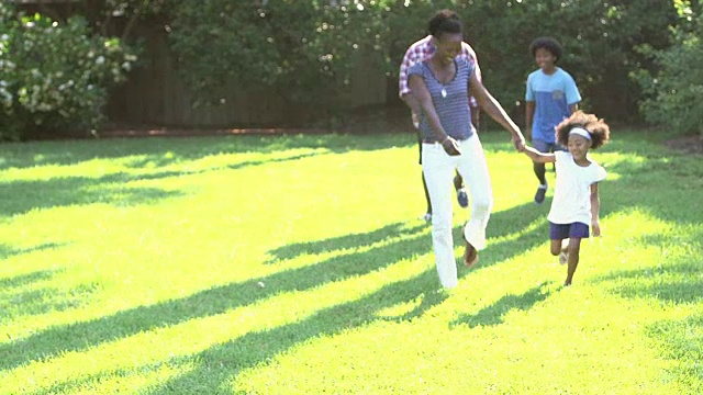 一个黑人家庭带着两个孩子在阳光明媚的户外视频素材