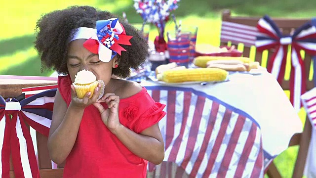 小女孩在国庆日野餐时享用纸杯蛋糕视频素材