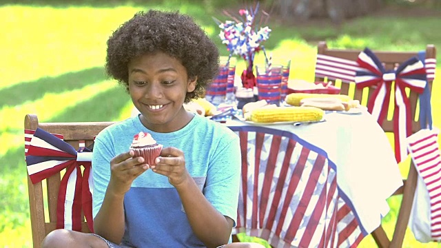 7月4日，男孩在野餐会上享用纸杯蛋糕视频素材