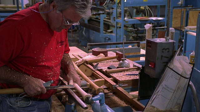 在肯塔基州路易斯维尔棒球队工厂，一名中等投手在测量和使用车床塑造棒球棒视频下载