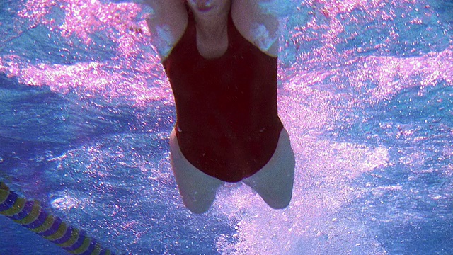 低角度中镜头女游泳运动员蝶泳向相机/加州视频下载