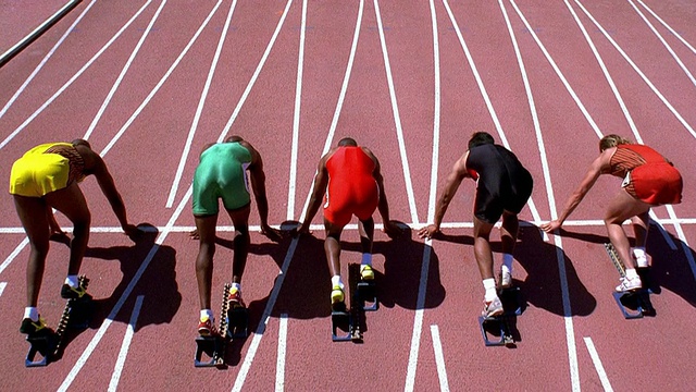 高角度宽镜头倾斜男性运动员开始设置起跑线和开始赛跑视频下载