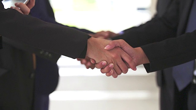 两个人的商业握手，表明他们同意在他们的公司/公司/企业之间签署协议或合同。视频素材