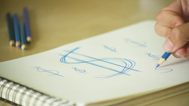 一个人用彩色铅笔画美元符号的手的特写视频下载