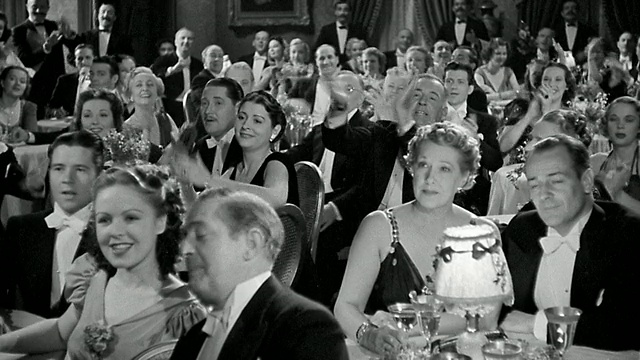 1940宽镜头男女在正式餐厅站立+鼓掌表演视频素材