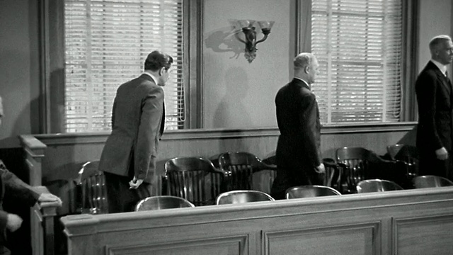 20世纪40年代的广角镜头12名男女陪审员走进法庭，站着或坐在陪审员席上视频素材