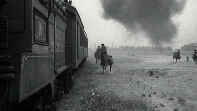 跟踪骑在马背上的火车劫匪，他们在行驶的火车旁骑马，然后跳上火车视频下载