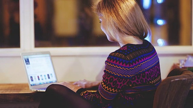 一名年轻女子在咖啡馆使用笔记本电脑视频素材