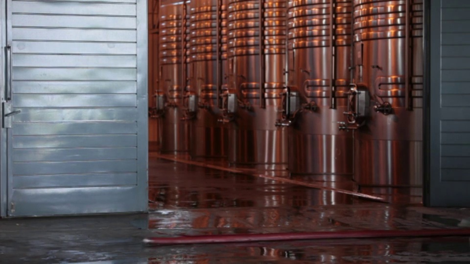 酿酒师拖软管过去不锈钢罐在Ruca Malen酒庄。视频下载