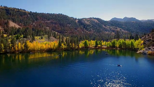 美丽的无人机跟踪风景的一个湖在荒野与渔民钓鱼在早晨的阳光。视频素材