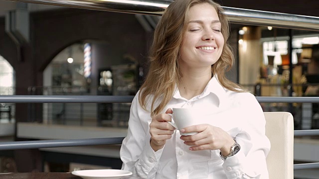 愉快的女性喝咖啡，而坐在咖啡馆视频下载