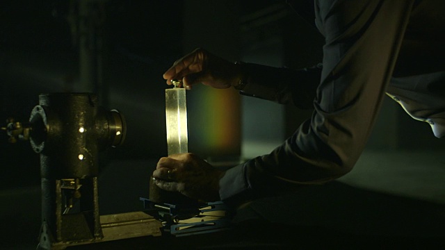 显示一个棱镜在一束光前的位置，从而在地下停车场的墙上产生一个投影光谱的序列。视频素材