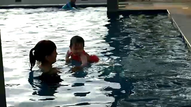 婴儿跳进游泳池向她的妈妈视频素材
