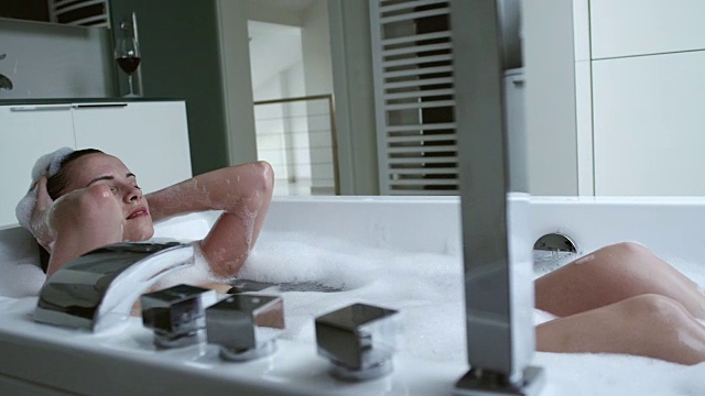 在现代浴缸中放松的女人视频素材