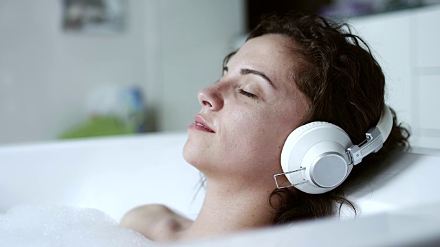 在浴缸里听音乐的女人视频素材