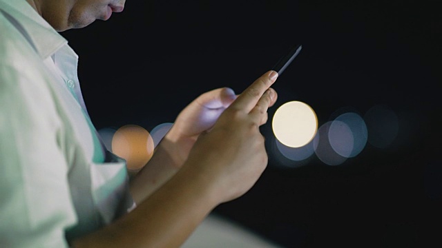 商业人士打字和使用智能手机，户外场景在晚上视频素材