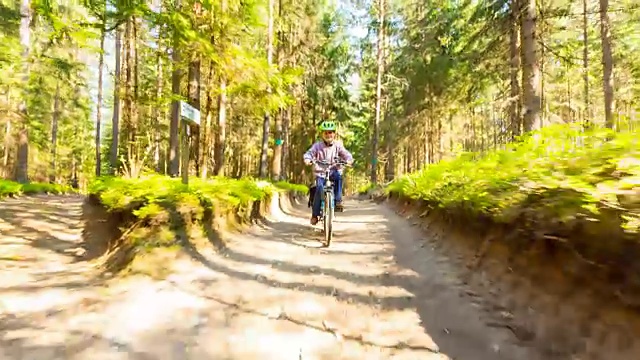 骑自行车穿过森林的男孩视频素材