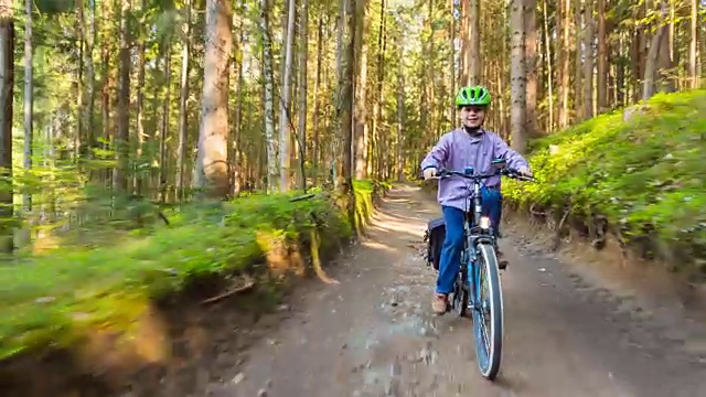 男孩骑自行车穿过森林视频素材