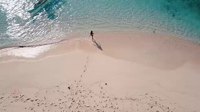 从空中(无人机)拍摄的一名女子走进海洋视频素材