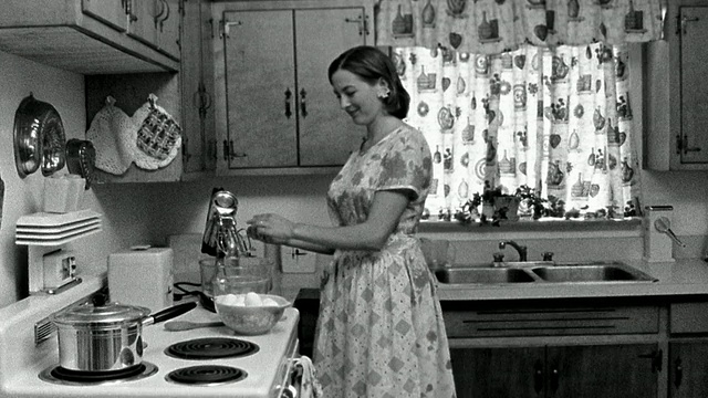 中景:再现了女人在厨房把鸡蛋打到搅拌碗里，然后离开的场景视频下载