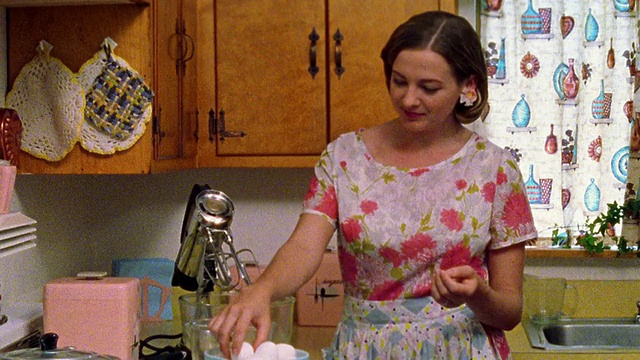中镜头再现了厨房里女人把鸡蛋打到搅拌碗里的情景视频素材