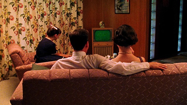 中景再现家庭在客厅看电视/电视屏幕为绿色，使用色度键视频下载