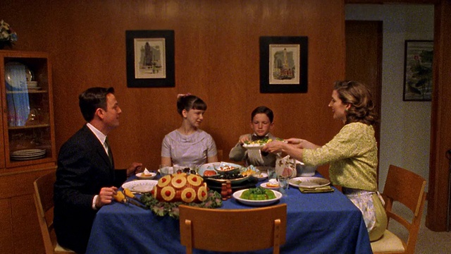 中景重现一家人在餐桌上传递食物的场景视频下载