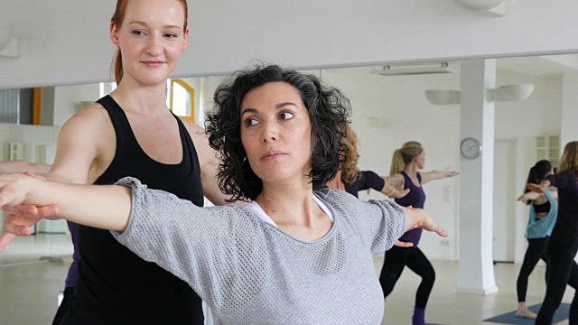 瑜伽教练在健身俱乐部帮助女性视频素材