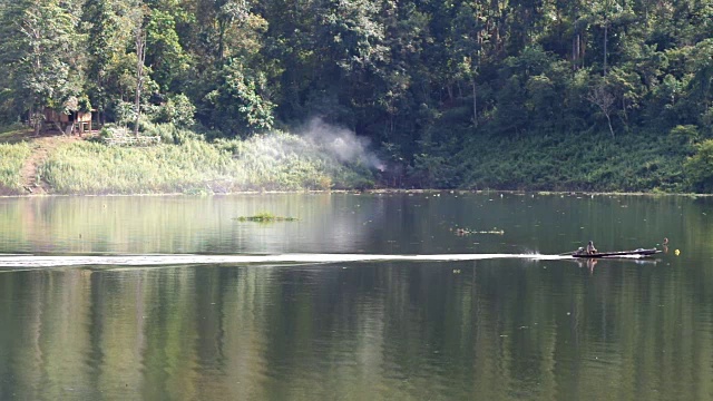 自然和景观概念，传统的船与热带雨林和山脉在河上行驶的镜头视频下载