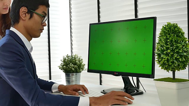 两个人对着绿色屏幕的电脑使用视频素材