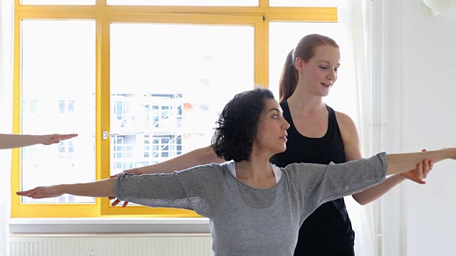 瑜伽教练在健身俱乐部帮助女性视频素材
