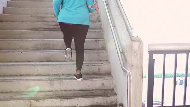 黑人妇女在城里锻炼，跑上楼梯视频素材